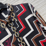 Pucci vintage print set: a combination of a draped shirt paired with high-waisted wide-leg pants, featuring contrasting wave patterns and classic chain elements. Shirt in sizes S, M, and L