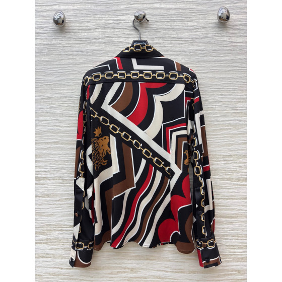 Pucci vintage print set: a combination of a draped shirt paired with high-waisted wide-leg pants, featuring contrasting wave patterns and classic chain elements. Shirt in sizes S, M, and L
